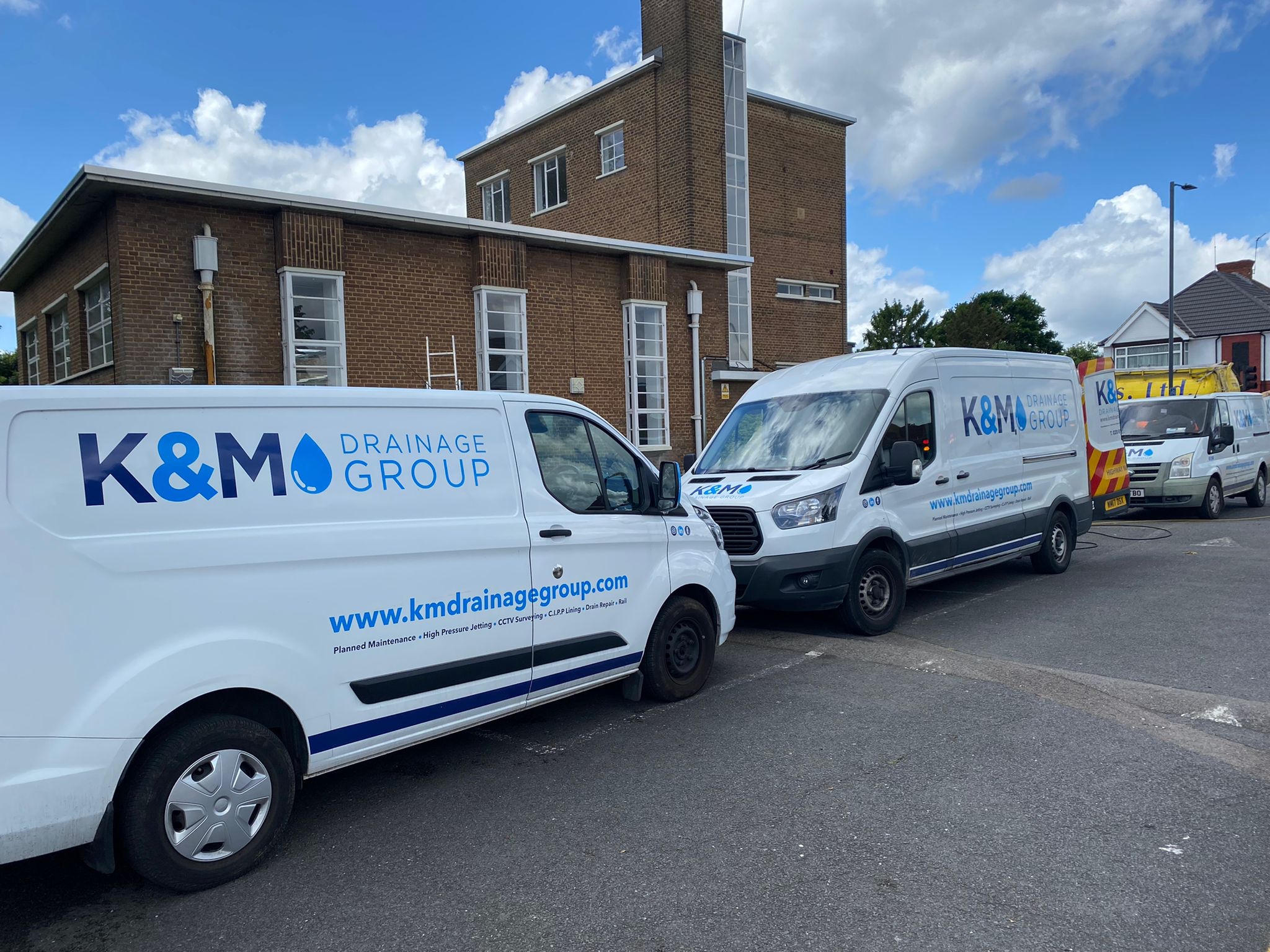 Row of branded K&M Drainage vans